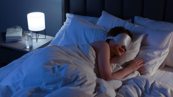 mulher deitada dormindo com uma máscara de dormir prata