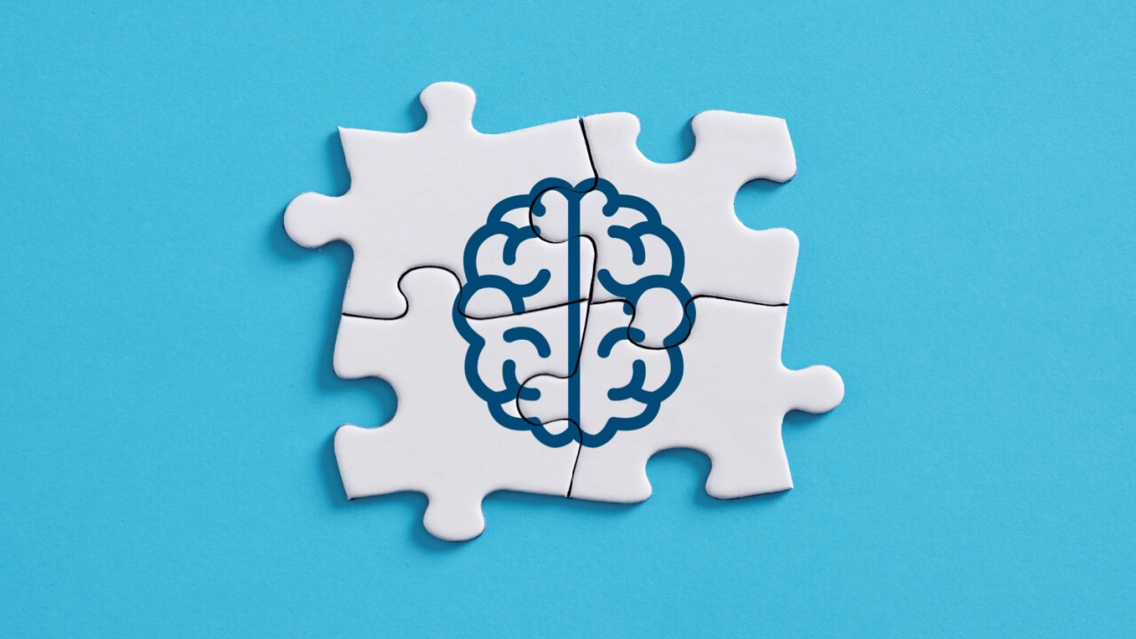 quatro peças de um quebra cabeça que formam o desenho de um cérebro em contorno azul e em fundo azul