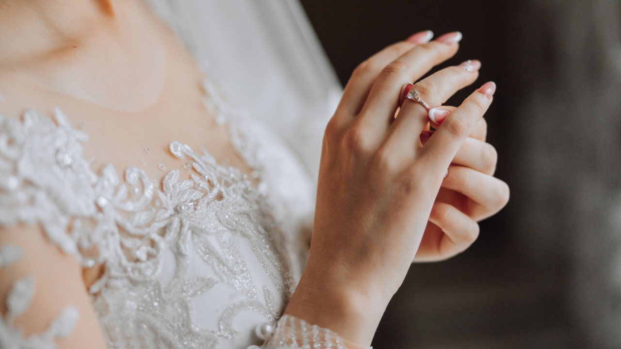 imagem de uma noiva focado nela colocando aliança na mão