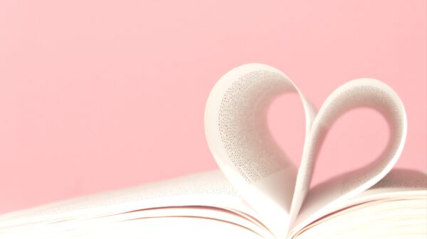 imagem da união de duas páginas de livro formando um coração em fundo rosa