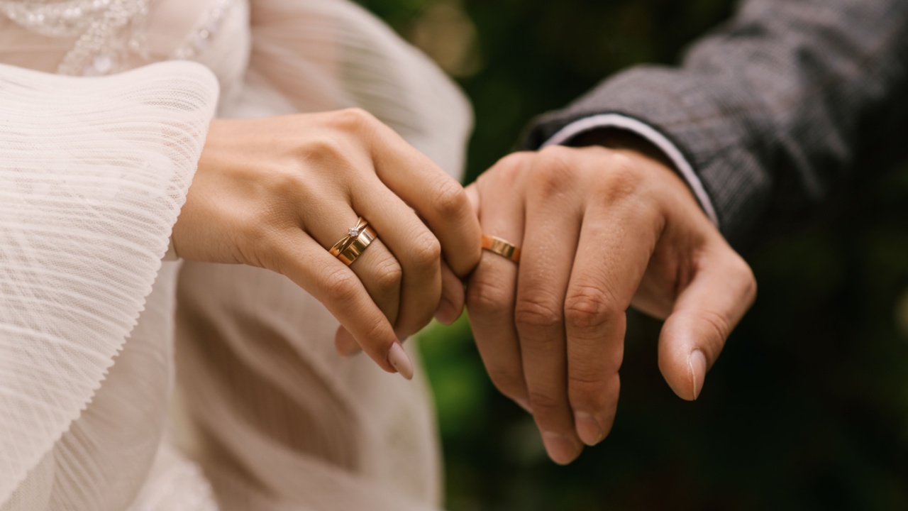 mãos de um casal mostrando a aliança de casamento