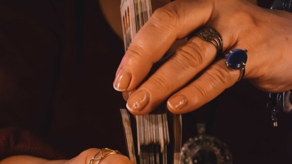 mão feminina segurando um baralho cigano