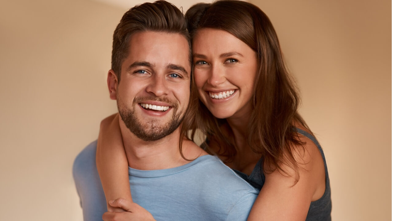 Retrato de um casal sorrindo e abraçado, unido. Homem e mulher felizes. Conceito de relacionamento saudável, apoio e conexão no amor.