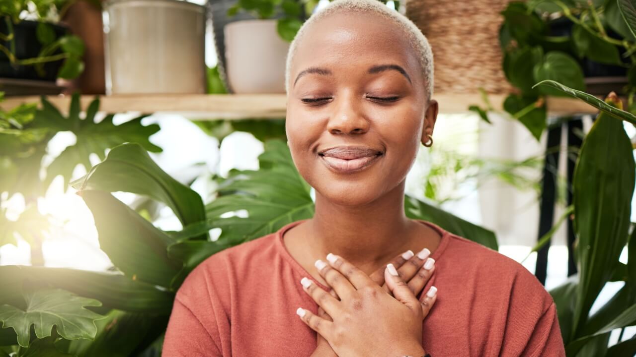 mulher negra meditando entre plantas