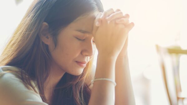 mulher de traços coreanos fazendo oração