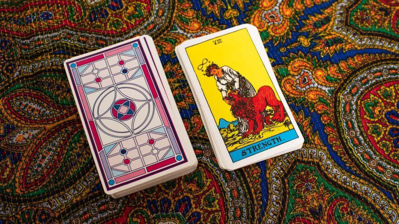 imagem da carta a força do tarot em uma tapete colorido