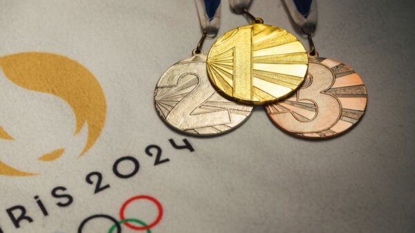 imagem das medalhas de ouro, prata e bronze em cima de um papel branco com o logo das olimpíadas de paris