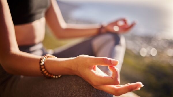 fotografia focada nas mãos de uma mulher meditando ao ar livre