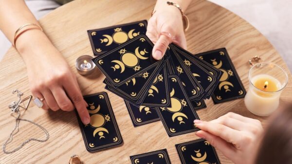 Mulher jogando cartas de tarô em uma mesa.