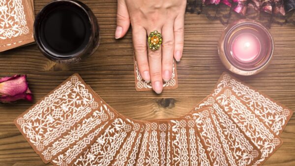 mulher com as mãos em cima das cartas de tarot