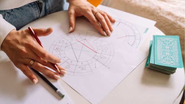 Uma astróloga desenhando com um lápis um mapa natal.