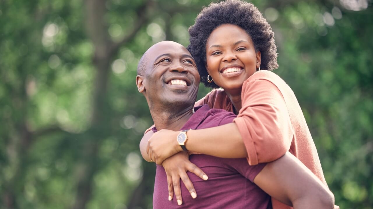 casal abraçados em um campo aberto com fundo verde desfocado