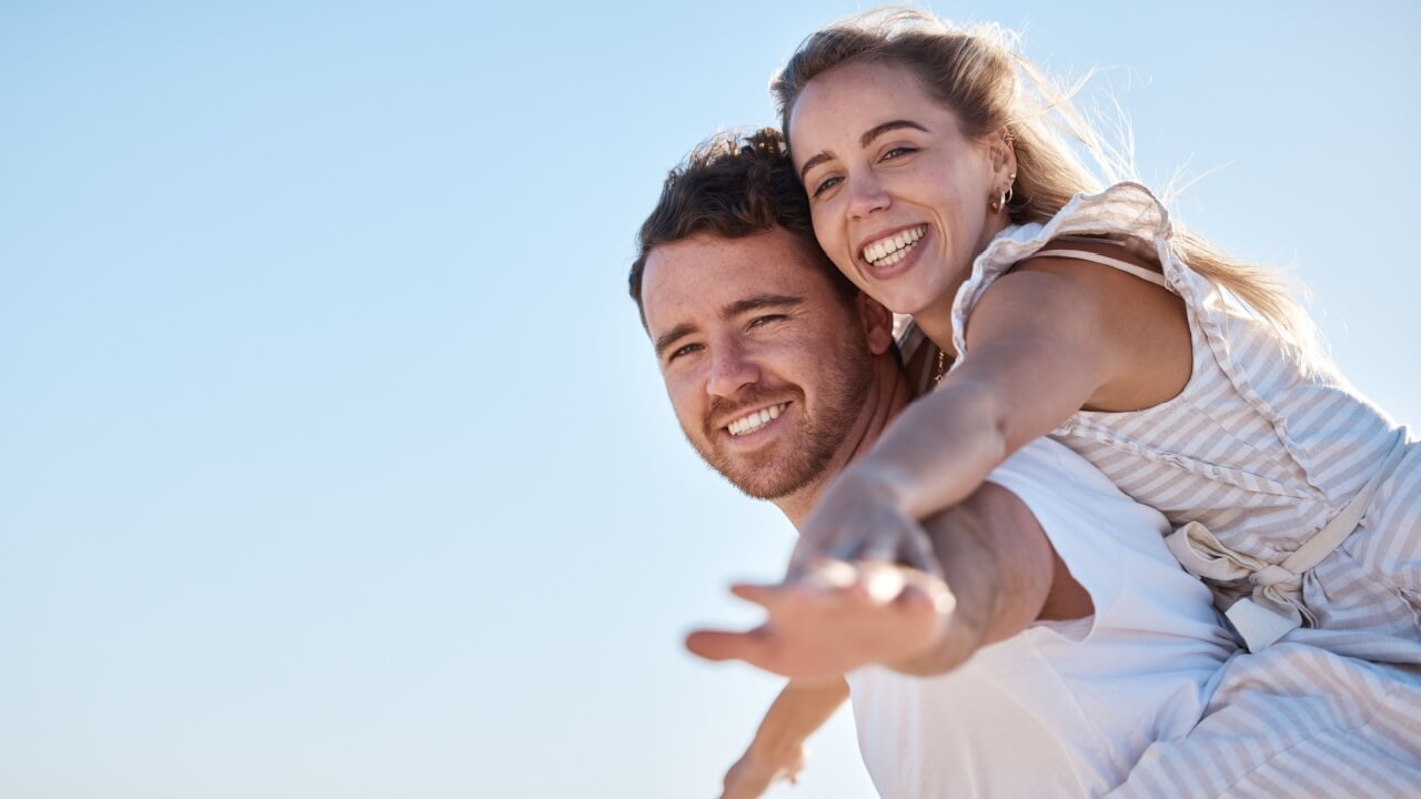 Céu azul e casal de mulher e homem feliz junto ao ar livre.