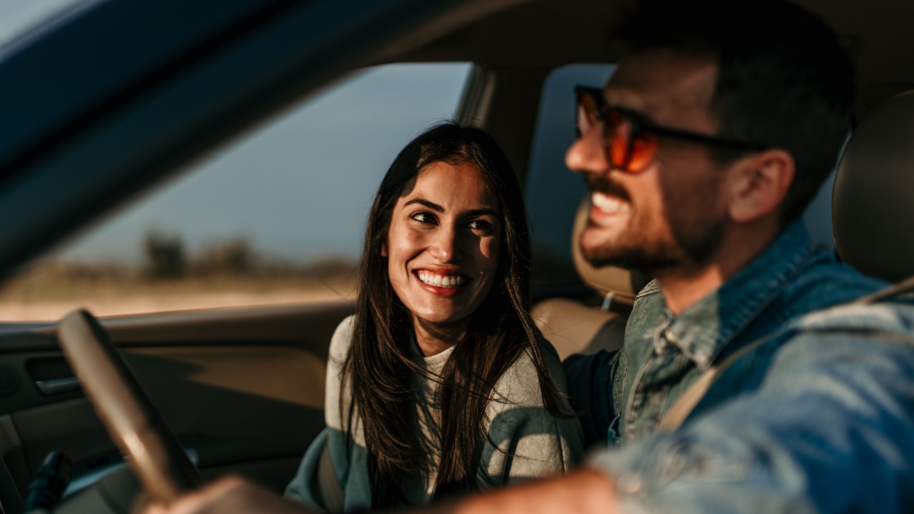 casal sorrindo dentro de um carro