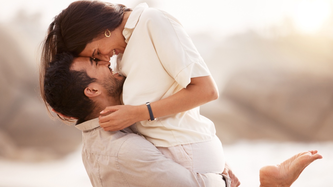 Casal feliz se abraçando na praia