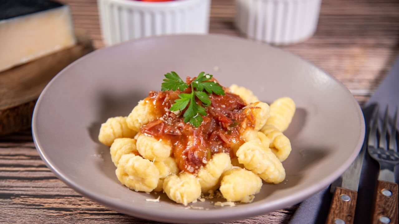 foto de um prato de nhoque com molho a bolonhesa