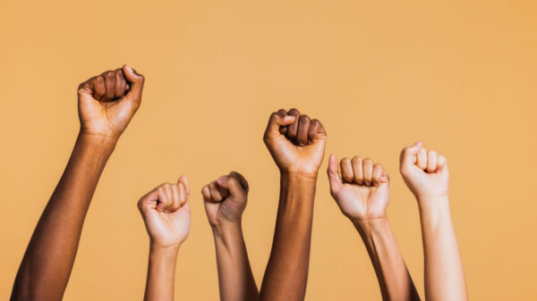 Mãos levantadas com punhos fechados, simbolizando poder e determinação.