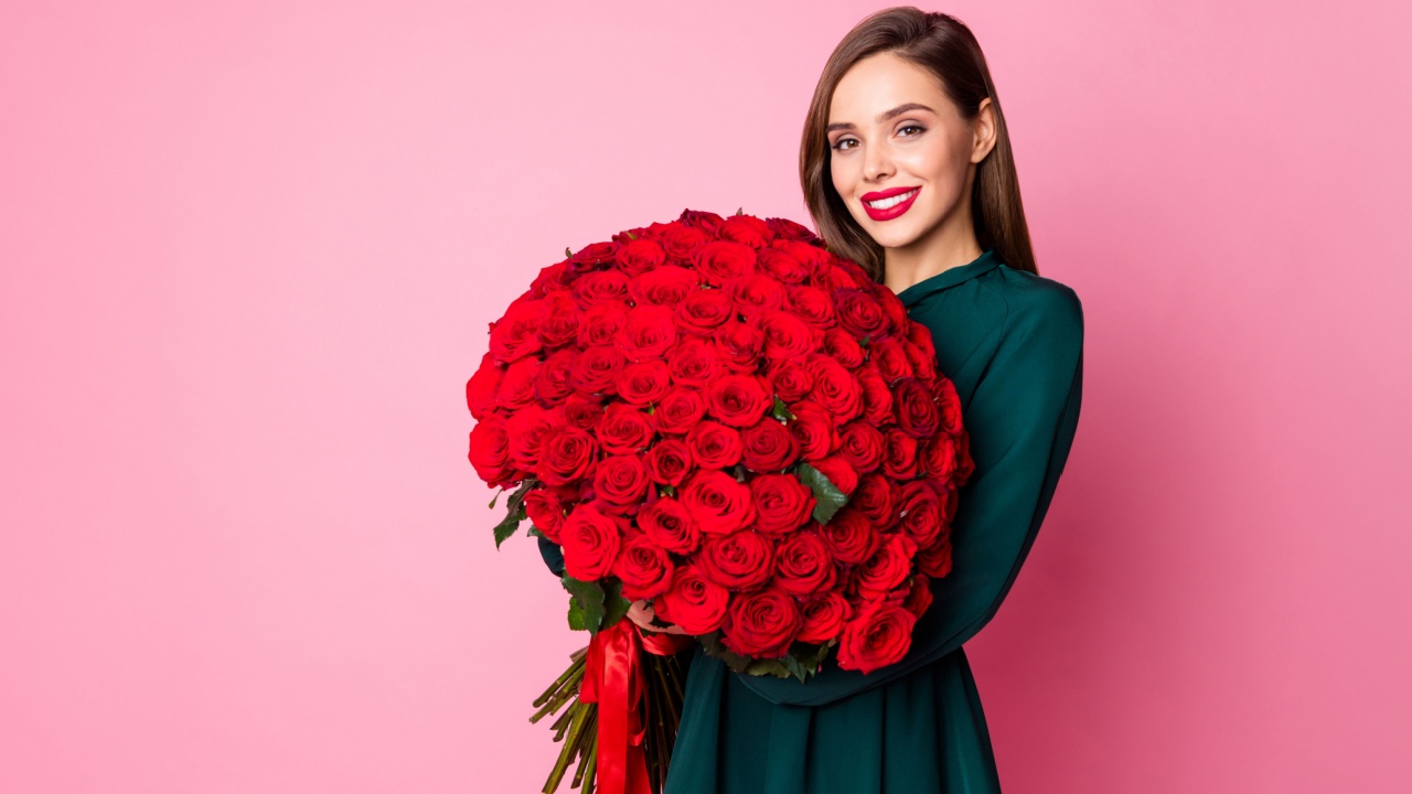 mulher segurando um buque de rosa vermelha em fundo rosa