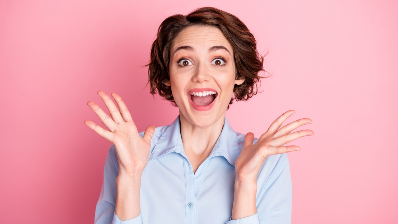 mulher com expressão de felicidade em fundo rosa