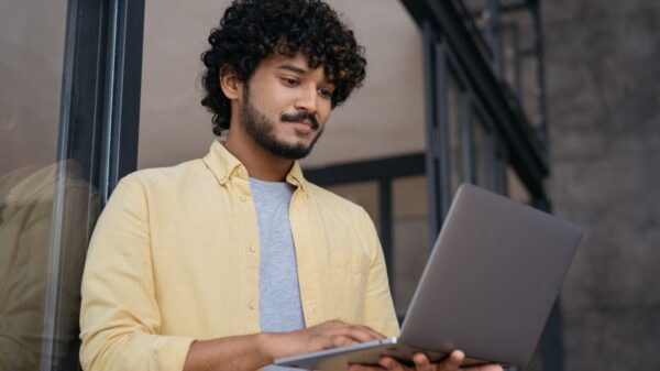 homem trabalhando em pé segurando um notebook