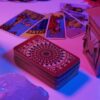 imagem de uma mesa com cartas de tarot iluminadas por luz roxa