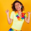 Mulher com roupas de carnaval, dançando com colar de flores.